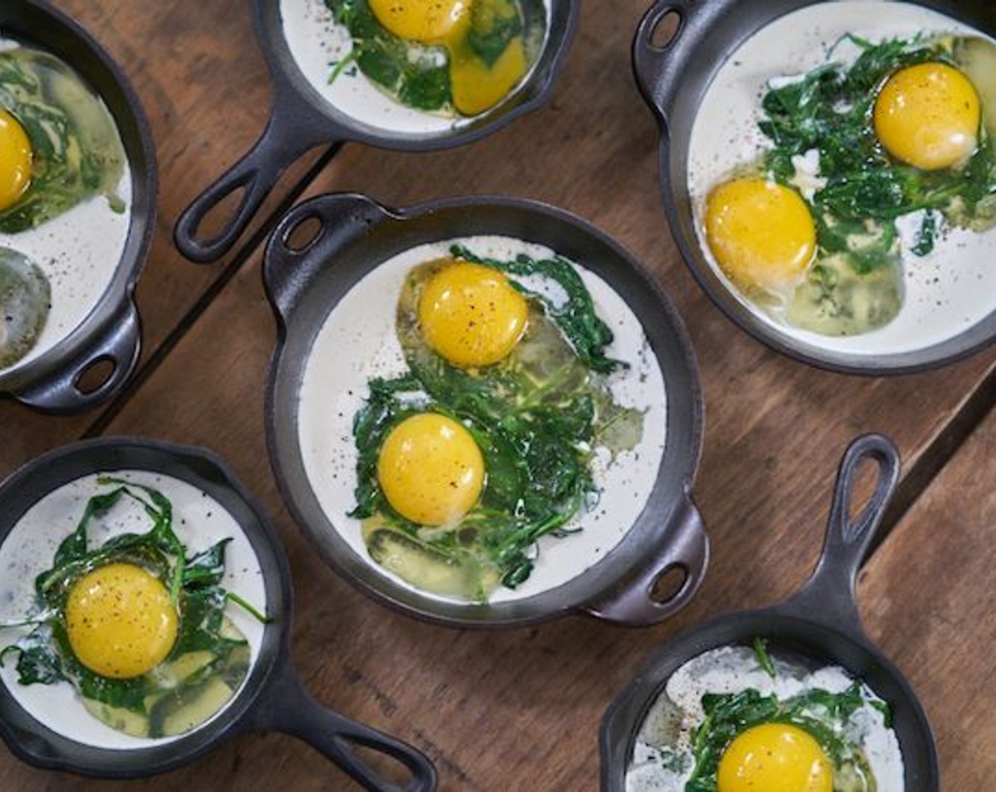 step 6 Create a small well in the spinach, and crack two Eggland's Best Classic Eggs (8) into each container. Season with Kosher Salt (to taste) and Freshly Ground Black Pepper (to taste).