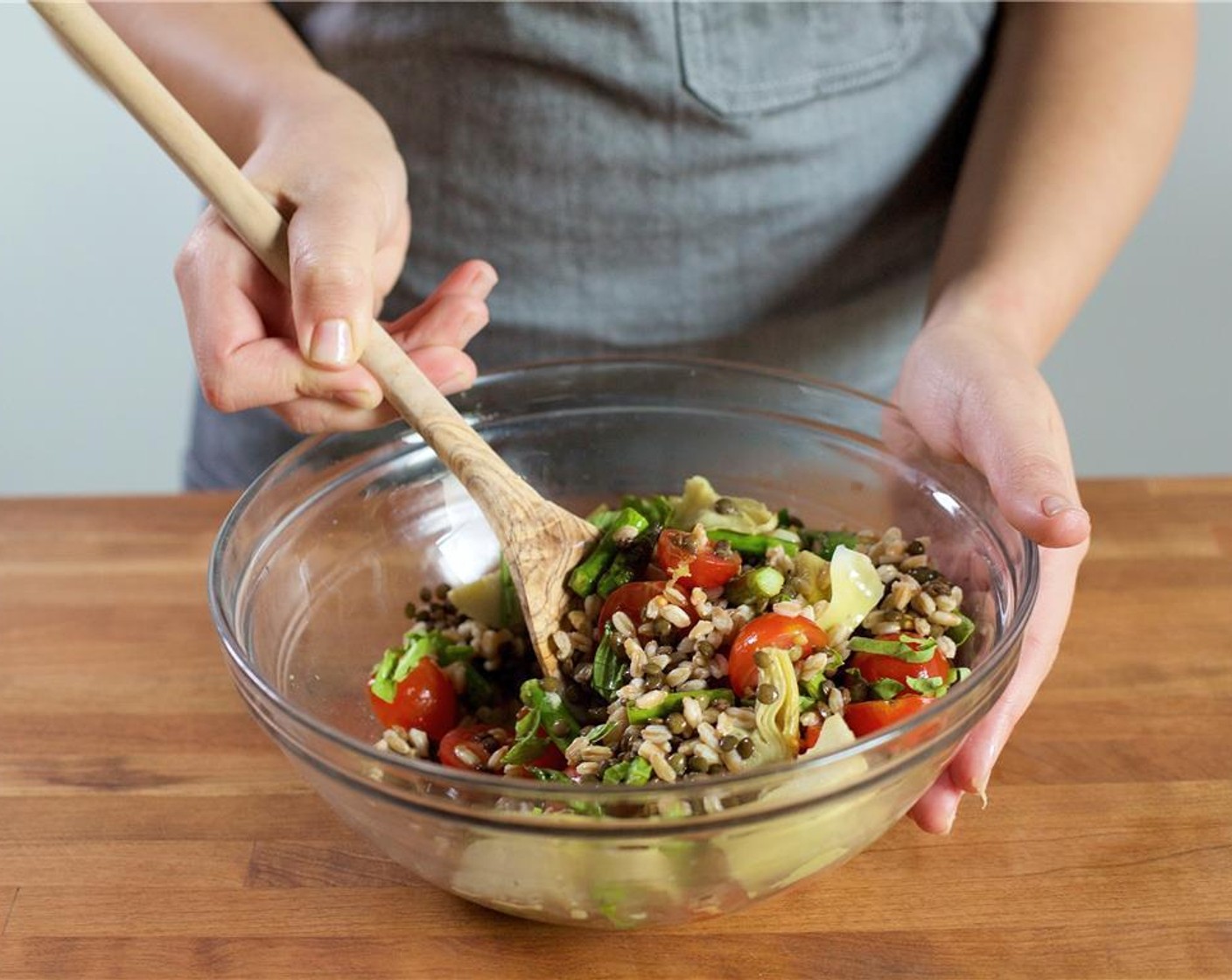 step 8 Using a colander, drain faro and lentils and add to the bowl with the vinaigrette. Mix to combine. Add in Cherry Tomato (1 cup), asparagus, artichoke hearts, lemon zest, and half of the basil. Gently mix to combine.